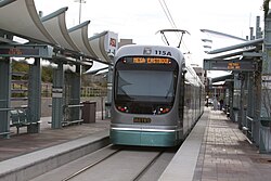 ภาพถ่ายรถไฟฟ้ารางเบาดีไซน์ล้ำสมัยกำลังแล่นเข้าสถานี