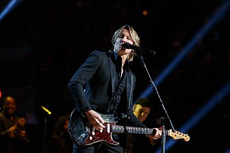 Keith Urban แสดงคอนเสิร์ตในงานประกาศรางวัล Gershwin Prize for Popular Song ประจำปี 2020 ของหอสมุดรัฐสภา ณ DAR Constitution Hall ในกรุงวอชิงตัน ดี.ซี. โดย Urban กำลังเล่นกีตาร์และร้องเพลงผ่านไมโครโฟน