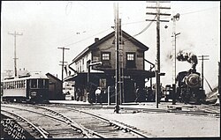 สถานีรถไฟไม้สองชั้นตั้งอยู่ตรงจุดตัดของสองเส้นทาง รถรางวิ่งอยู่บนเส้นทางด้านซ้าย และรถไฟไอน้ำวิ่งอยู่บนเส้นทางด้านขวา