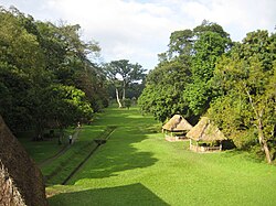 พื้นที่ราบโล่งปกคลุมด้วยหญ้า มีต้นไม้เรียงรายอยู่สองข้างทาง มีหลังคามุงจากคลุมอนุสาวรีย์อยู่บ้าง และมีทางเดินและร่องระบายน้ำอยู่ทางด้านซ้าย