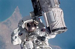 STS104-315-013 (12–24 กรกฎาคม 2544) --- นักบินอวกาศ Michael L. Gernhardt ผู้เชี่ยวชาญภารกิจ STS-104 จับยึดส่วนปลายของแขนกล Canadarm บนกระสวยอวกาศแอตแลนติส และเข้าร่วมในการเดินอวกาศหนึ่งในสามครั้งของภารกิจ STS-104