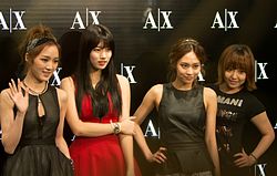 ภาพของมิสเอ โดยมีโลโก้ของ Armani Exchange อยู่ด้านหลัง