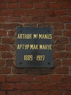 แผ่นโลหะบนผนังอิฐพร้อมจารึก: Arthur MacManus/Артур Макманус, 1889–1927