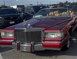 รถเปิดประทุน Cadillac สีแดง พร้อมกระจังหน้าและที่วางแขน และเบาะหนังสีน้ำตาลอ่อน