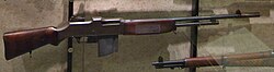 ปืนไรเฟิลอัตโนมัติบราวนิง M1918 รุ่นแรก แสดงภาพด้านข้าง มีลำกล้องยาว ขาตั้งสองขาแบบตายตัว และพานท้ายไม้