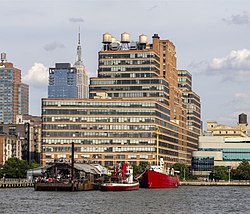 อาคาร Starrett–Lehigh มองเห็นได้จากแม่น้ำฮัดสัน เรือสีแดงลำหนึ่งจอดอยู่ที่ท่าเทียบเรือด้านหน้า