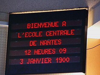 ป้ายอิเล็กทรอนิกส์ฝรั่งเศส ข้อความว่า Bienvenue a L'École centrale de Nantes, 12 heures 09, 3 Janvier 1900.